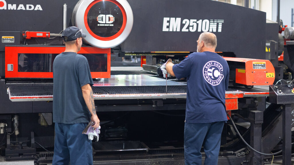 Two technicians working at an Amada punch press